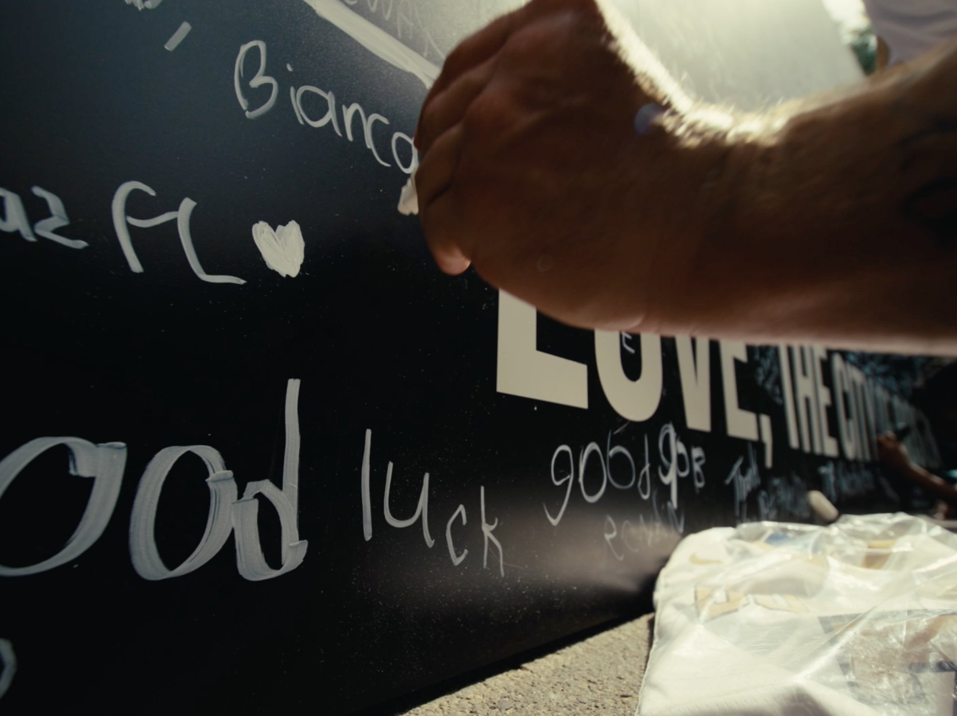 Close-up of a fan signing a farewell wall for Jaylen Brown