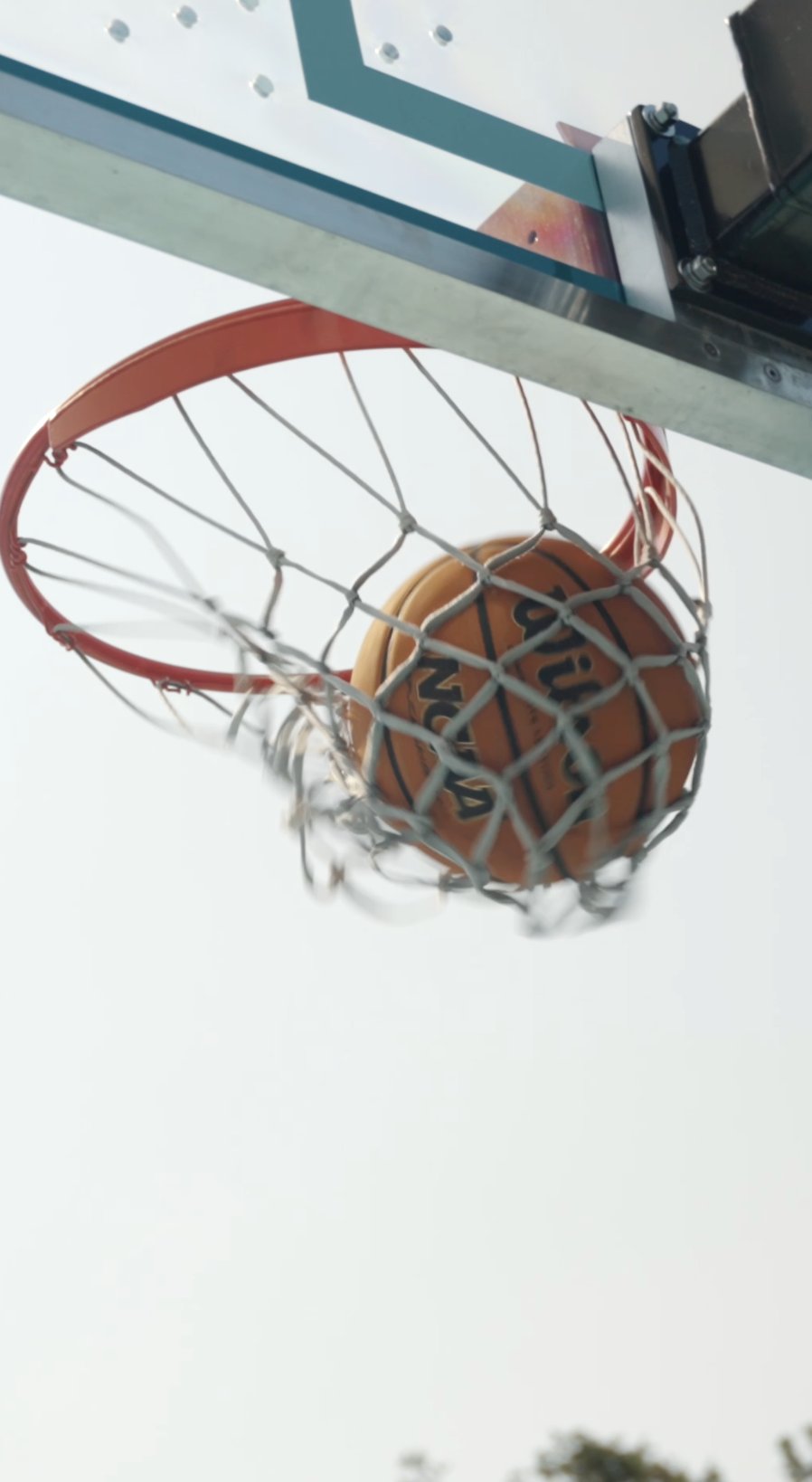 Low-angle shot of a basketball dropping through the net