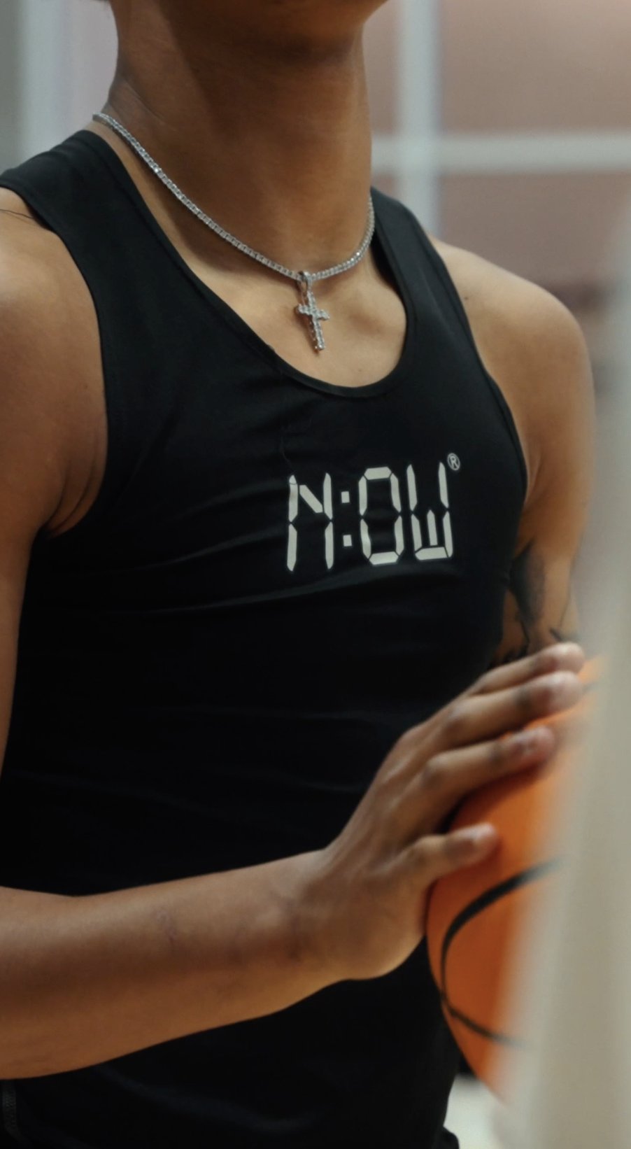 Close-up of a player's N:OW tank top and cross necklace