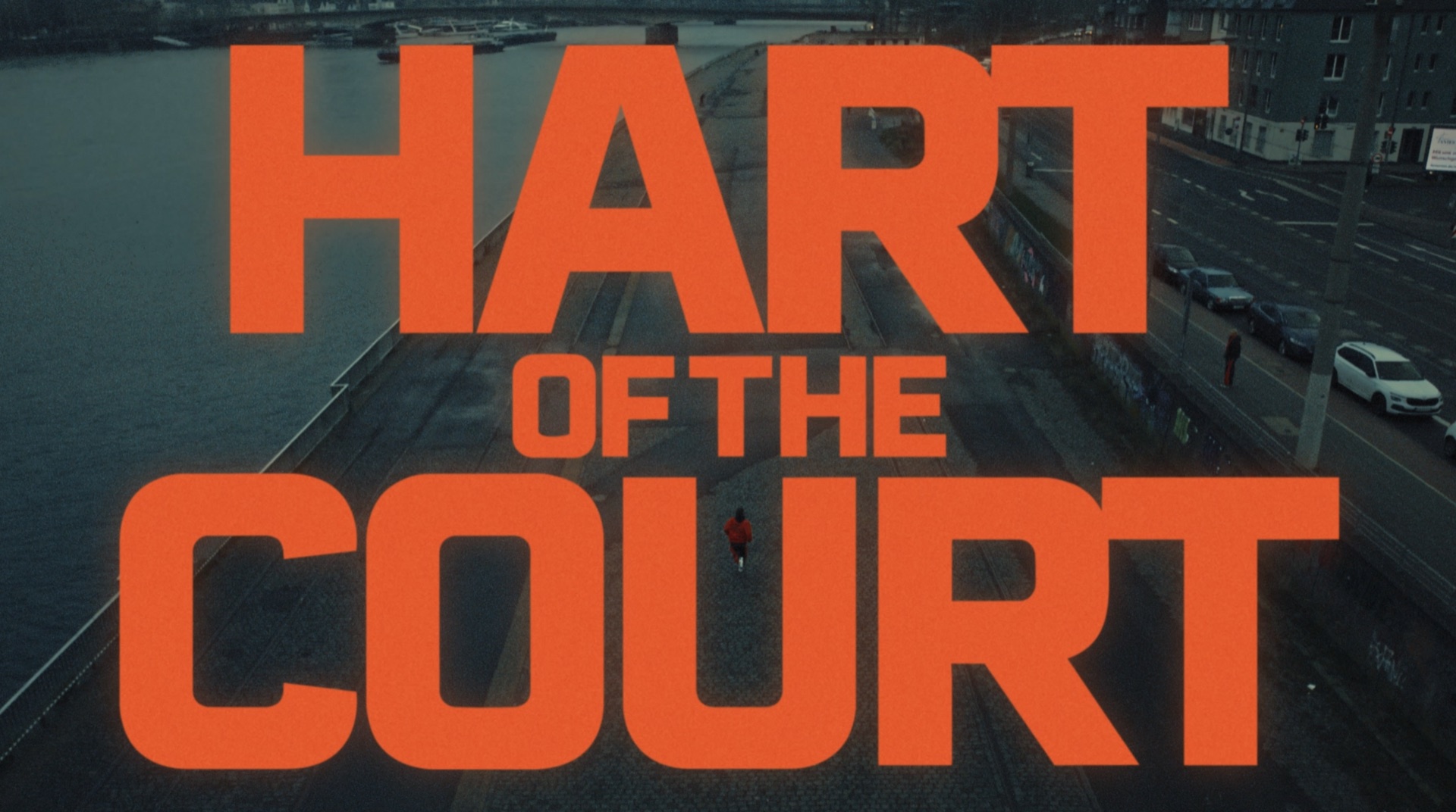 Bold orange HART OF THE COURT title card over aerial footage of a runner along a riverside promenade