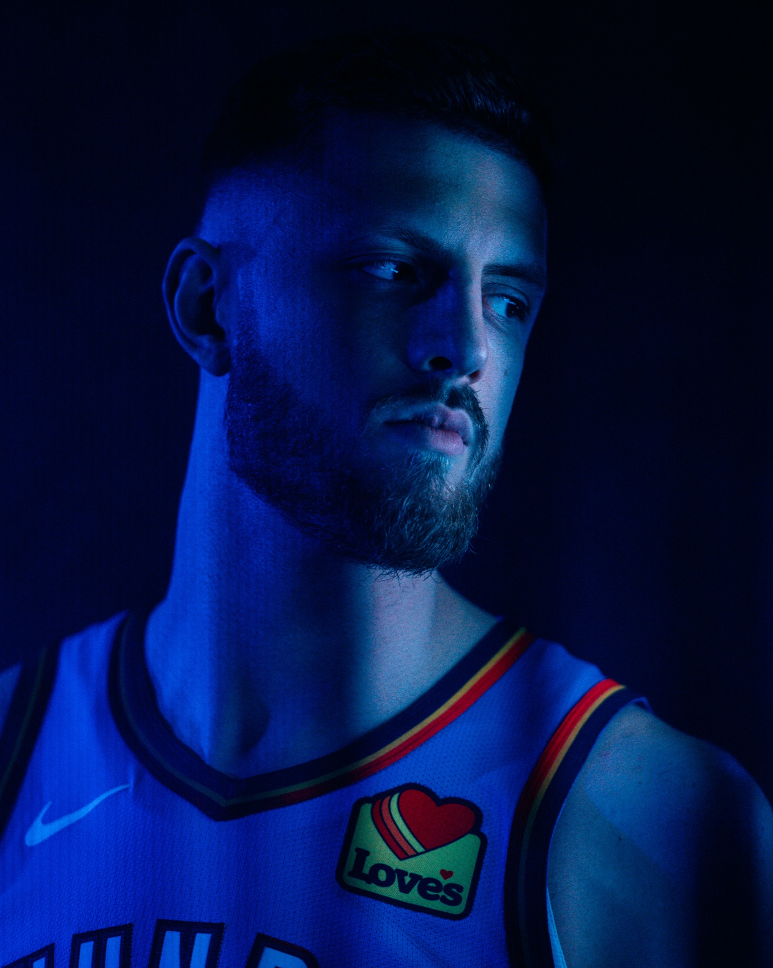 Moody blue-lit portrait of Isaiah Hartenstein in his Thunder jersey