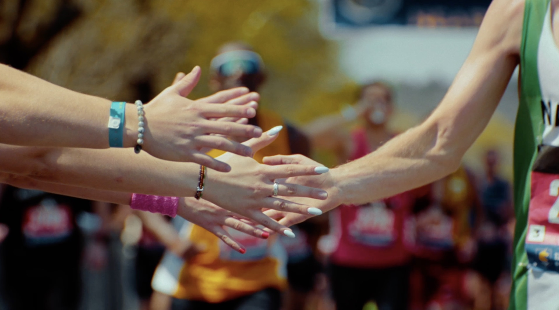 Close-up of spectators' hands reaching out to high-five a passing runner