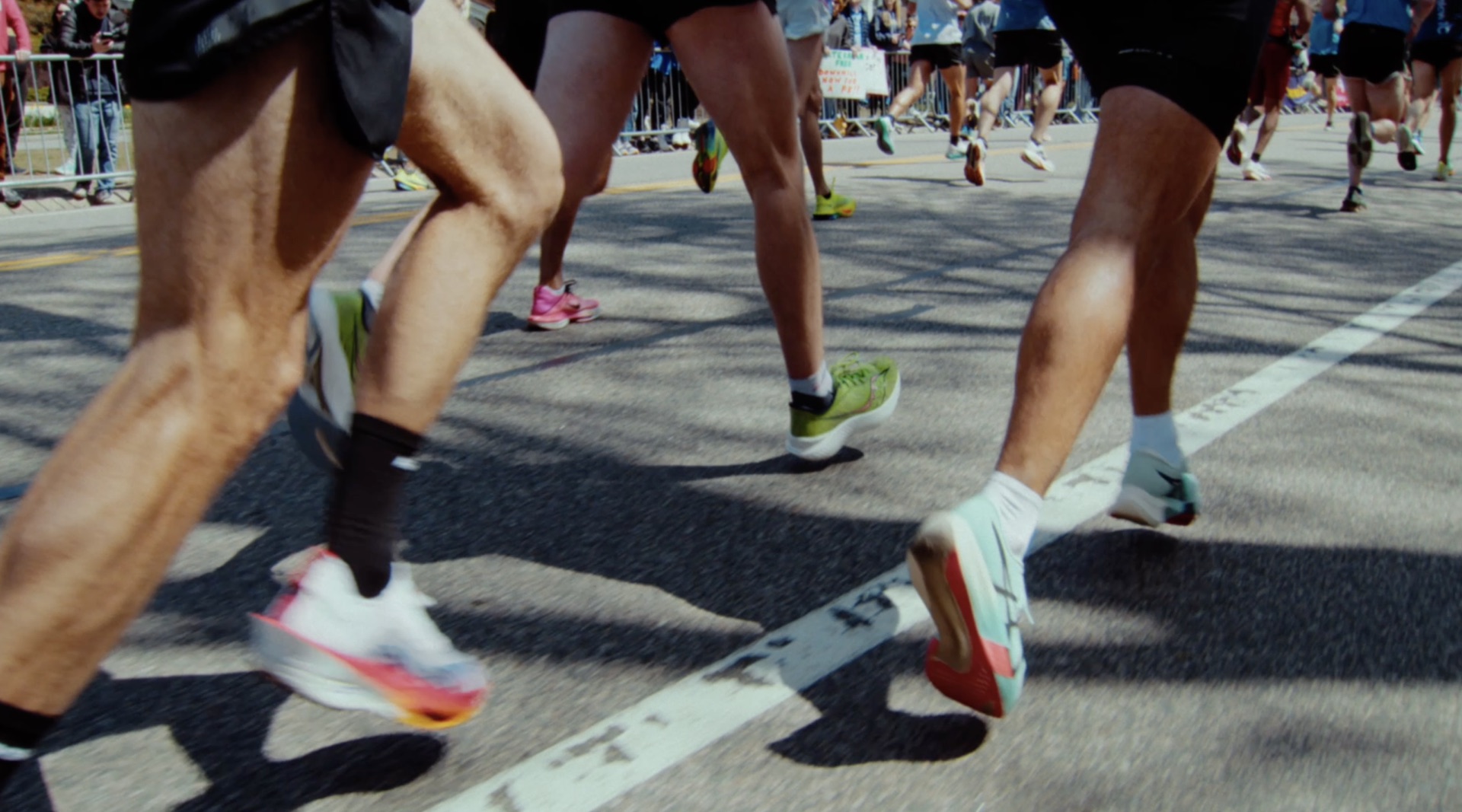 Low-angle shot of runners' legs and sneakers mid-stride on the course